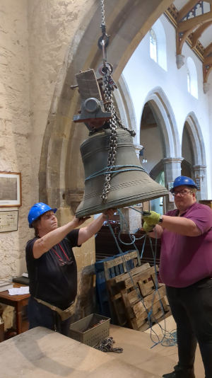 The first bell descends from the tower, Karen and Sam guide the 